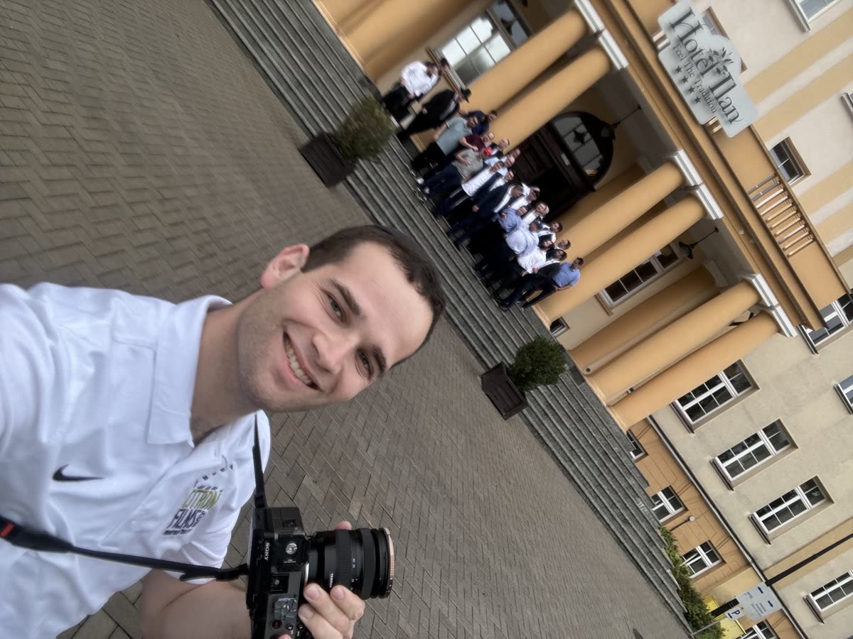 Yaakov with the camera, a group of boys lined up on the steps of a building behind him