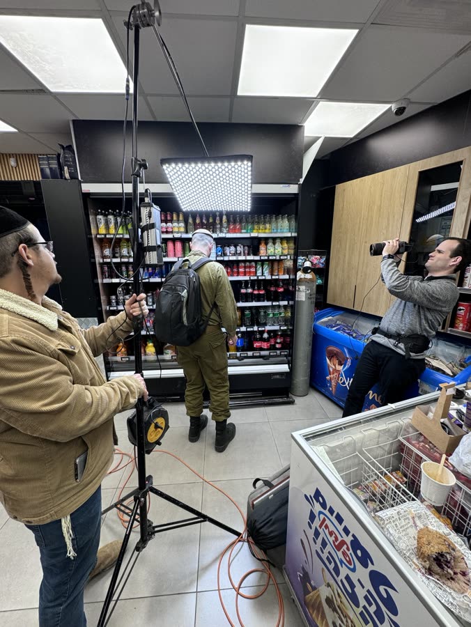 A soldier being filmed in a small store